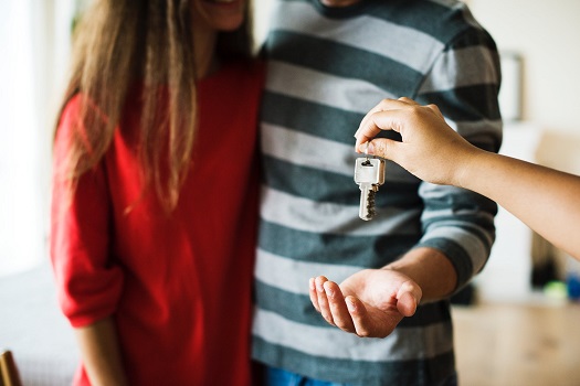 landlord handing keys to tenants